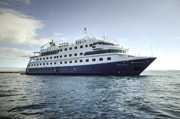 A larger Galapagos ship of 100 guests seen on its starboard side with a blue hull.