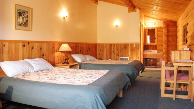 A room with two queen-sized beds at the Kantishna Roadhouse. Down comforters and warm quilts will keep guests warm and cozy on chilly Alaskan summer nights.