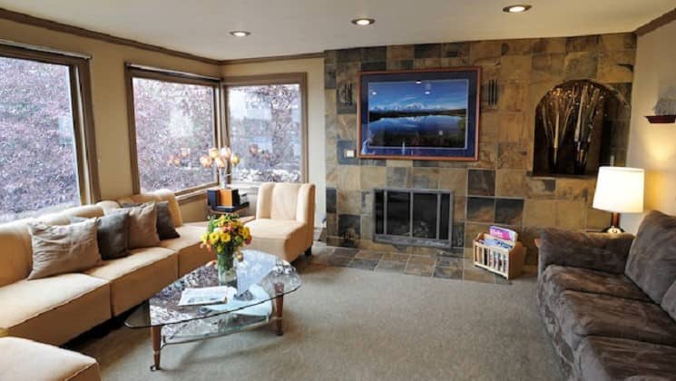 Large living room with two couches, art on walls and large windows at Copper Whale Inn in Anchorage, Alaska