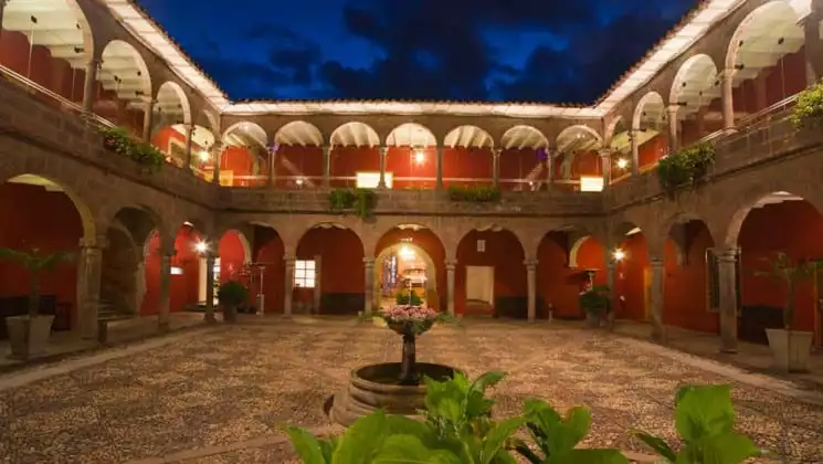 Large outdoor courtyard with small fountain centerpiece and several plants at Costa del Sol Ramada Cusco in Peru