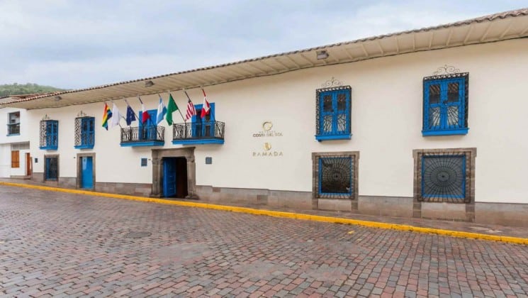 Exterior of Costa del Sol Ramada Cusco in Peru with international flags hanging above main entrance