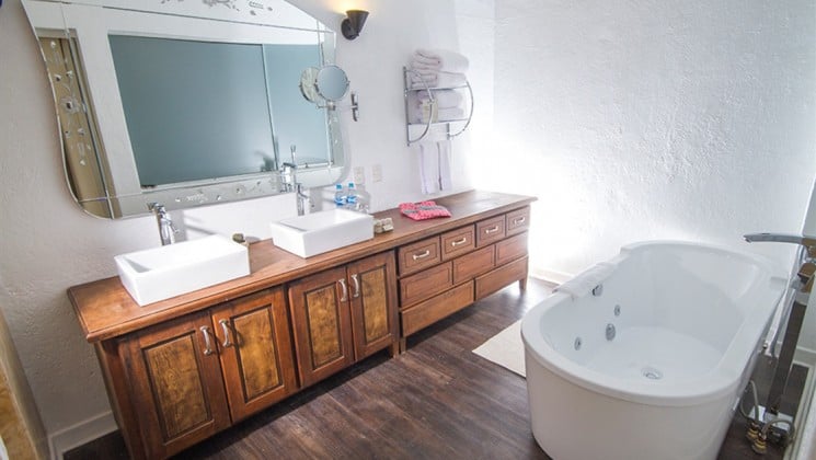 Bathroom with large soaking tub, two sinks and large mirror at El Mercado Tunqui in Cusco, Peru