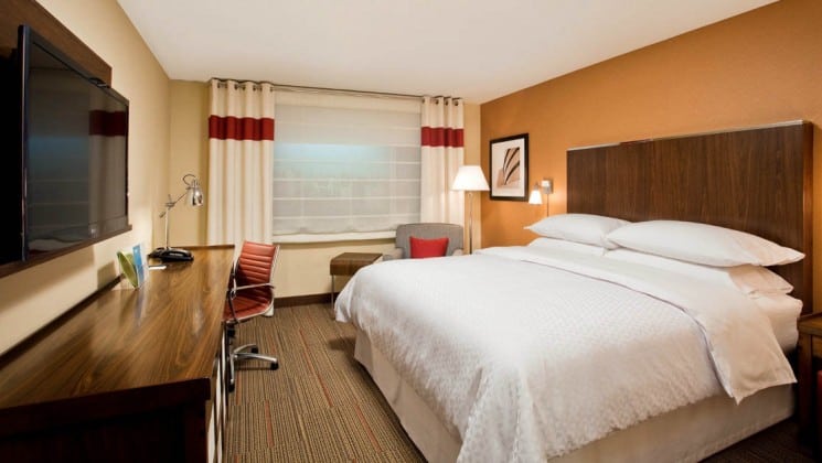 Room with king bed, desk, armchair, table, window, mounted TV at Four Points by Sheraton in Juneau, Alaska