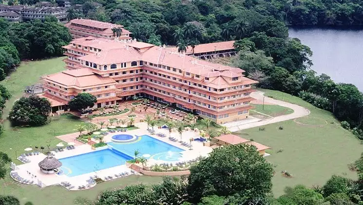 An aerial view of the Meliá Panamá Canal, a large hotel with a swimming pool near lush rainforest and Gatun Lake
