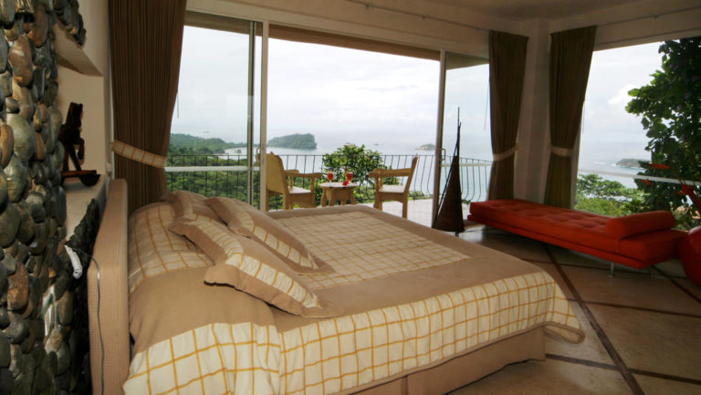The Premier Ocean View Room at Hotel La Mariposa offers a panoramic vantage of the Pacific Ocean in Costa Rica with a king-sized bed and private balcony.
