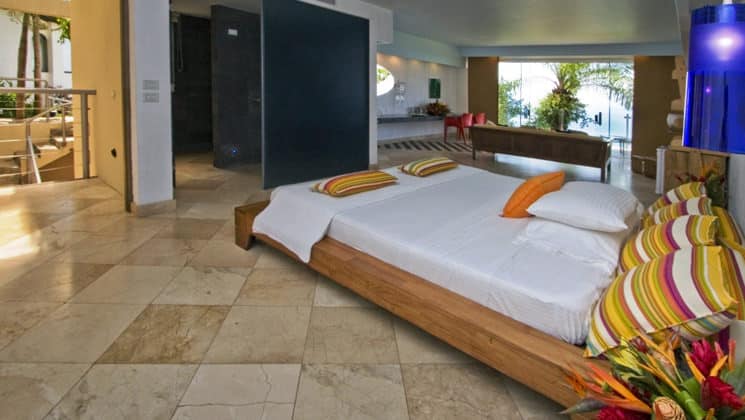 The Premier Room with a king-sized bed, private balcony, tiled floors, and modern decor at La Mariposa Hotel, one of Costa Rica's finest accommodations along the Pacific Ocean