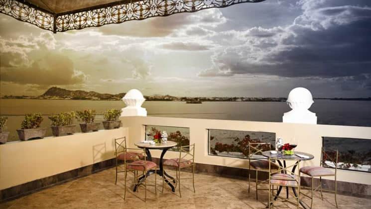 The patio with tables and chairs overlooks the river at dusk at the Mansion del Rio, a premier boutique hotel in Guayaquil, Ecuador