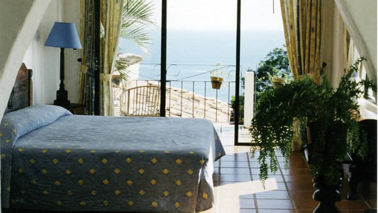 A room at La Mariposa Hotel with a queen-sized bed, private balcony, tiled floor offers guests comfort and relaxation with ocean views