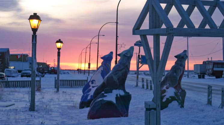Wolf statues at sunset outside Churchill Hotels on the snow-covered streets of the Arctic town of Churchill