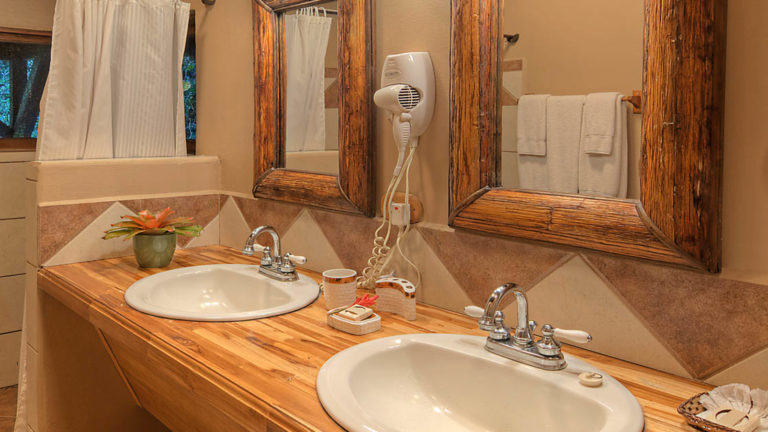 Two sinks on the vanity with a mirror in the private bathroom at the river view penthouse suite at Tortuga Lodge, a luxury eco resort in Costa Rica