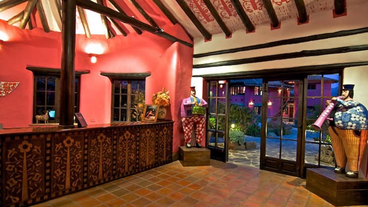 The lobby at Sol y Luna, featuring wooden beams and sliding glass doors leading to a garden, at the sustainable, luxury retreat in Urubamba, one hour’s drive from Cusco.