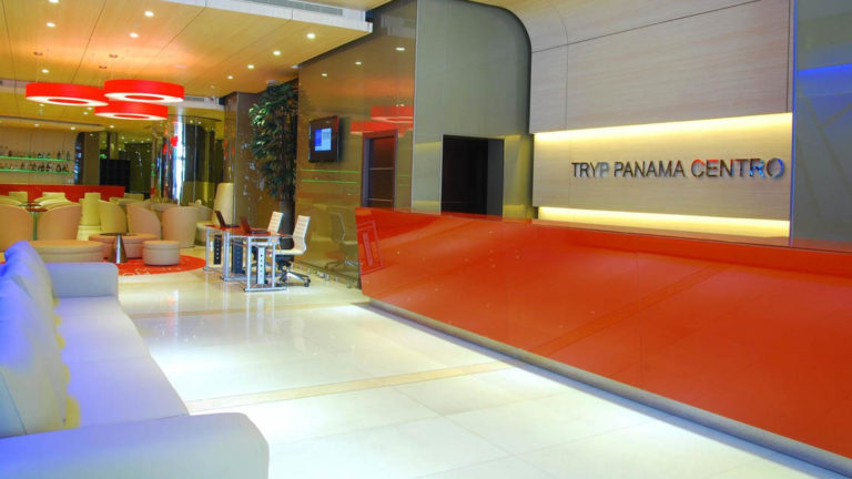 The reception desk in the contemporary lobby with seating, at the Hotel Tryp by Wyndham Panama Centro