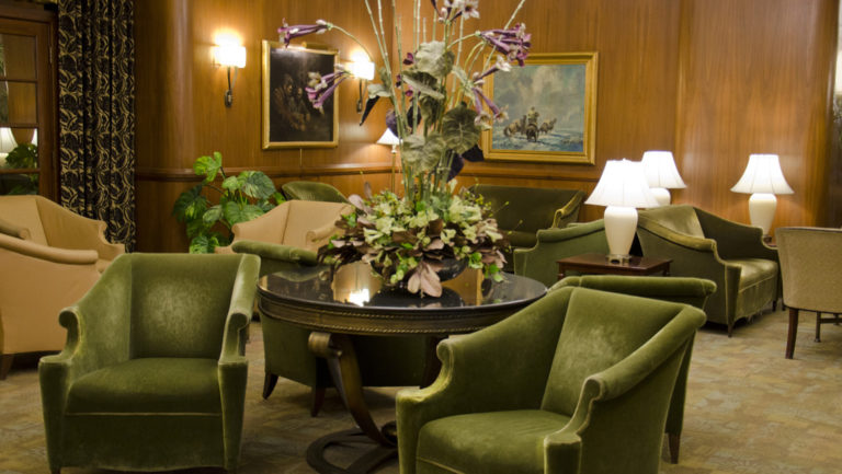 The art-deco lobby, with plush chairs, flowers, and tables, inside of the Hotel Baranof in Juneau, Alaska