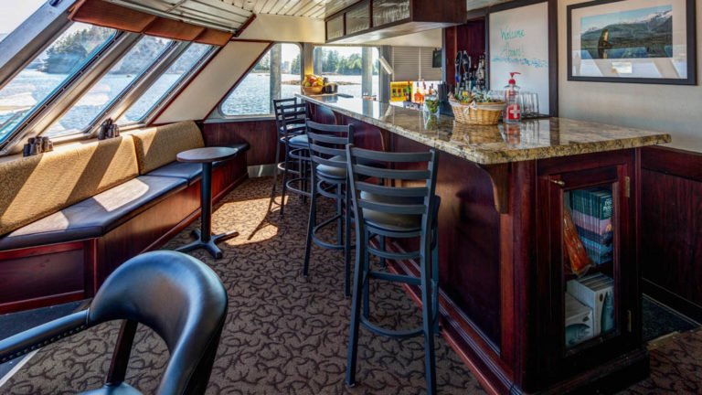 Bar with stools and benches by window aboard Alaskan Dream.