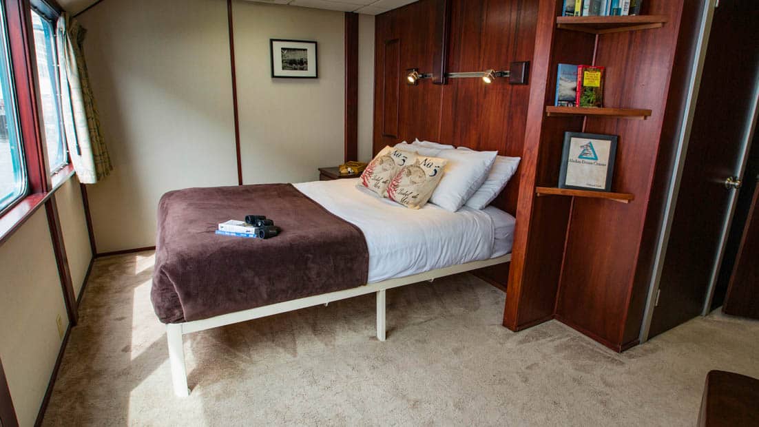 Owner's Suite aboard Alaskan Dream with large bed and window.