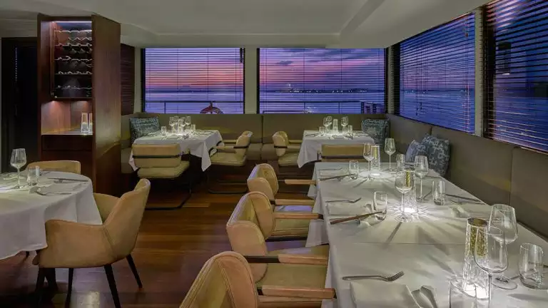 Dining room aboard aqua mekong with white table cloths and light brown chairs