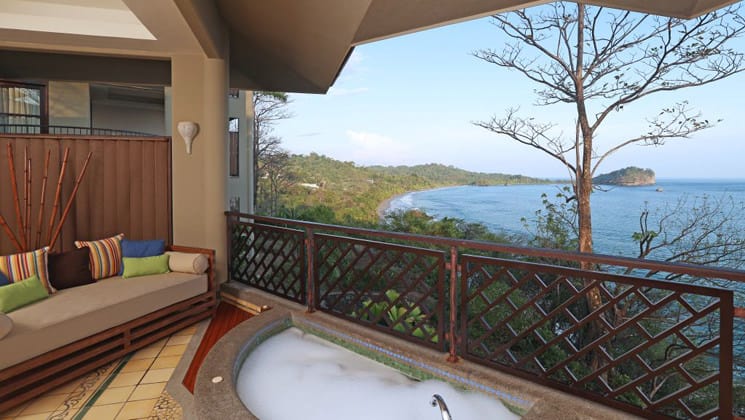 A hot tub on a balcony with an ocean view at Arenas Del Mar in Costa Rica