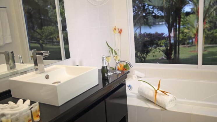 A contemporary bathroom with fresh flowers and white linens at the Bocas del Mar hotel in Panama