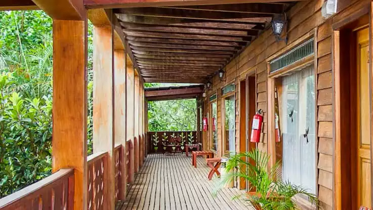 A covered porch in front of the rooms at the Hotel Heliconia in Costa Rica offers guests jungle views and opportunities for birdwatching