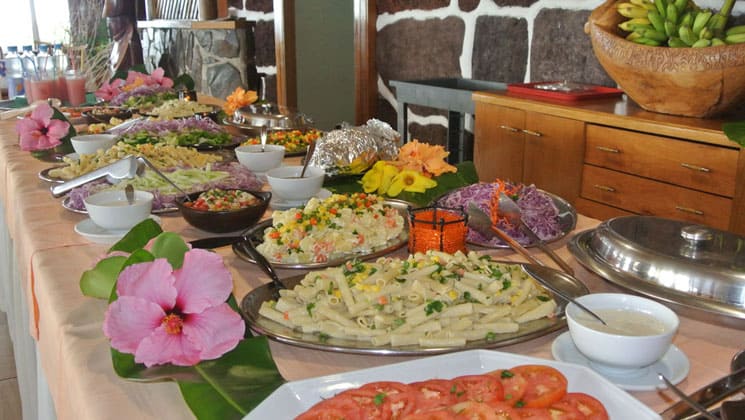 buffet table at hotel iorana easter island in chile with plates of bright fruit, vegetables and prepared dishes