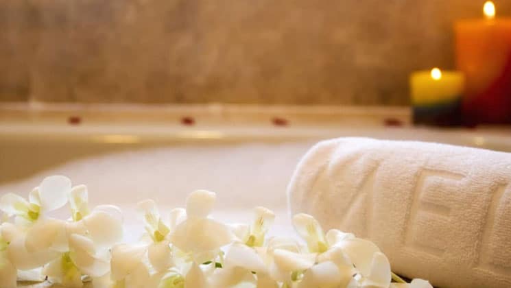 up close view of orchids and a branded towel in front of the bathtub at melia hotel panama canal