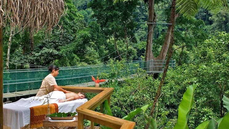 A guest receives a massage outdoors in a jungle setting at the Pacuare Lodge, a sustainable hotel in Costa Rica