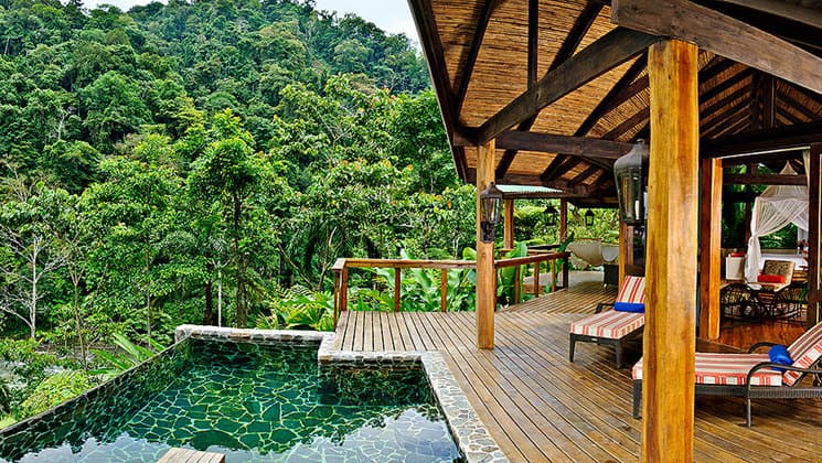 The pool at Pacure Lodge is set between an outdoor deck and the lush jungle, offering a relaxing wilderness ambience in Costa Rica