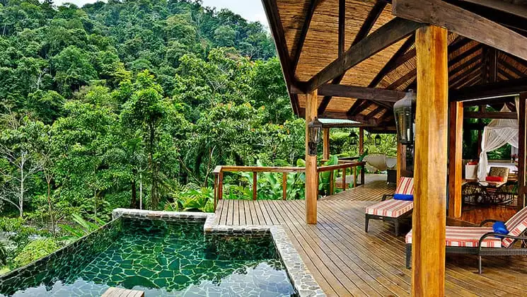 The pool at Pacure Lodge is set between an outdoor deck and the lush jungle, offering a relaxing wilderness ambience in Costa Rica