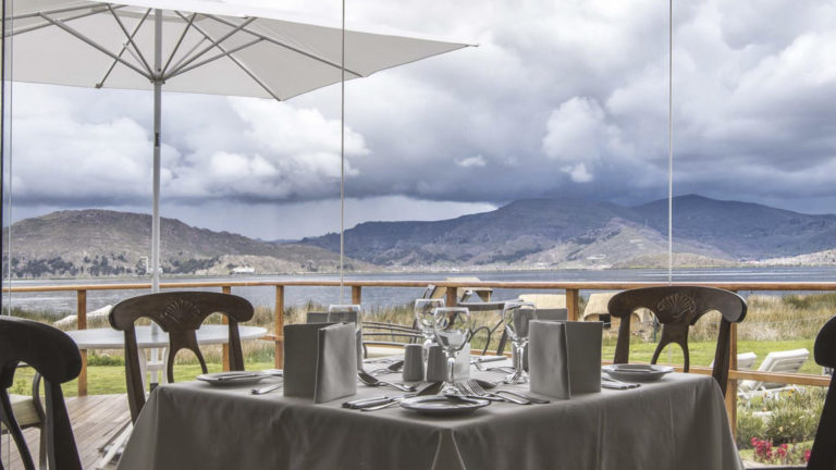 Tables are set on a balcony wiith a view of Lake Titicaca, for guests to dine at Sonesta Posadas del Inca, a lodge in the Andes