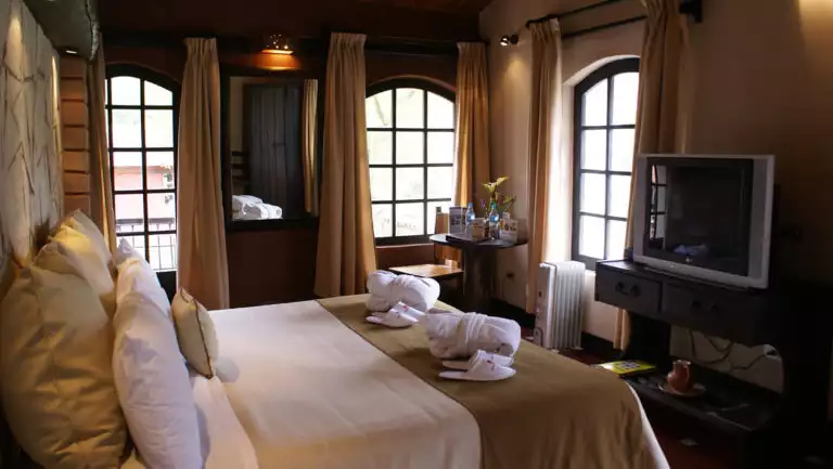 The standard room features a king-sized bed, television, and large windows at Sonesta Posadas Del Inca in Peru's Sacred Valley, a boutique hotel near Machu Picchu.