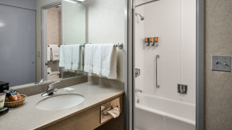 A bathroom inside a guest room with sink, vanity, and hot shower at the Westmark Anchorage, a downtown hotel that was recently renovated