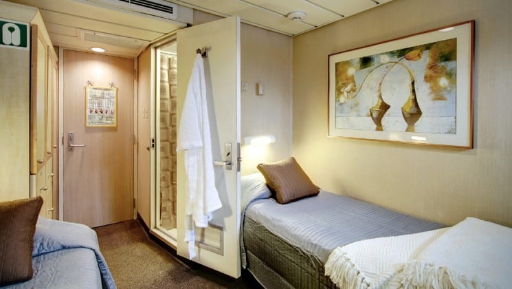 Safari endeavour Alaska small ship Navigator cabin with two beds, bathrobe on the wall and picture above the bed