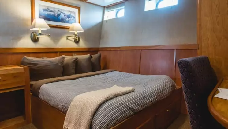 Navigator Stateroom C1 with fixed queen bed aboard Safari Quest. Photo by: UnCruise