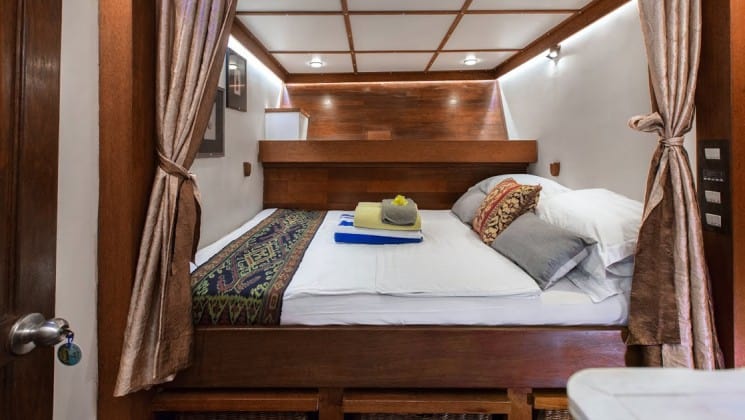 Katharina sailboat stateroom with double bed and upper shelf storage.
