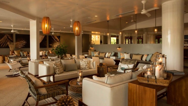 Lounge with couches, chairs, tables and abundant natural light at Finch Bay Eco Hotel in the Galapagos Islands