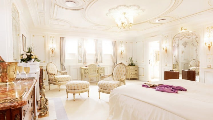 pristine white room with a large bed and ottomans aboard the Lindblad Sea Cloud luxury mediterranean small ship