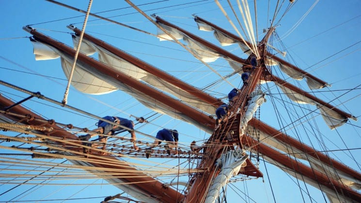 looking up at the Sea Cloud luxury mediterranean yacht mast with crew members climbing it