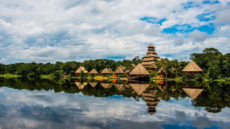 The triangular buildings of the Napo Wildlife Center reflect in the calm water of Anangucocha Lake. The sustainable eco lodge is surrounded by a 53,000 acre rainforest biosphere reserve within Yasuni National Park, offers luxury accommodations in Ecuador’s Amazon.
