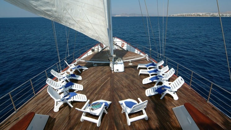 bow of the Panorama Mediterranean luxury yacht with chairs around the sail on a sunny day