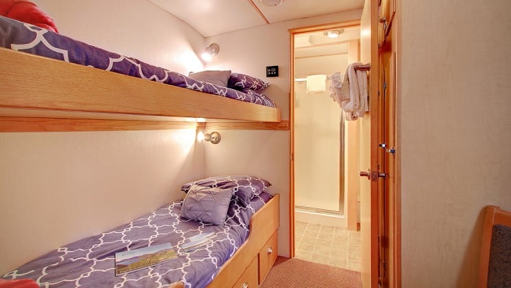 single cabin aboard the Safari Quest Alaska small ship, with bunk beds and a door leading into the bathroom