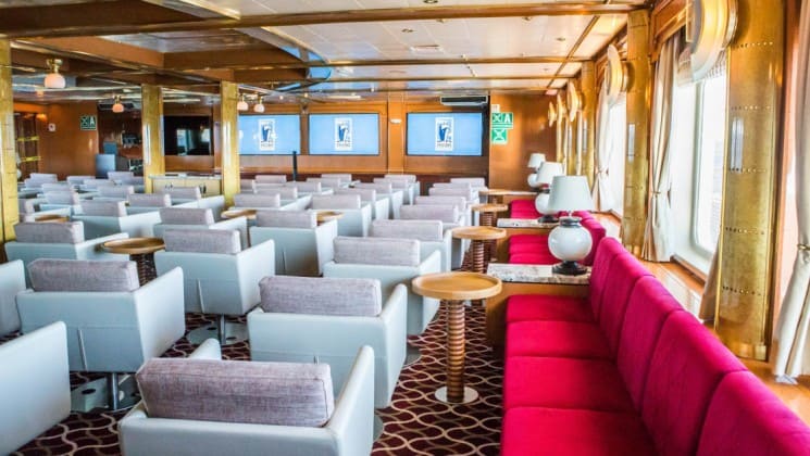 Couches and chairs set up in lounge with window-lined walls aboard Sea Spirit expedition ship