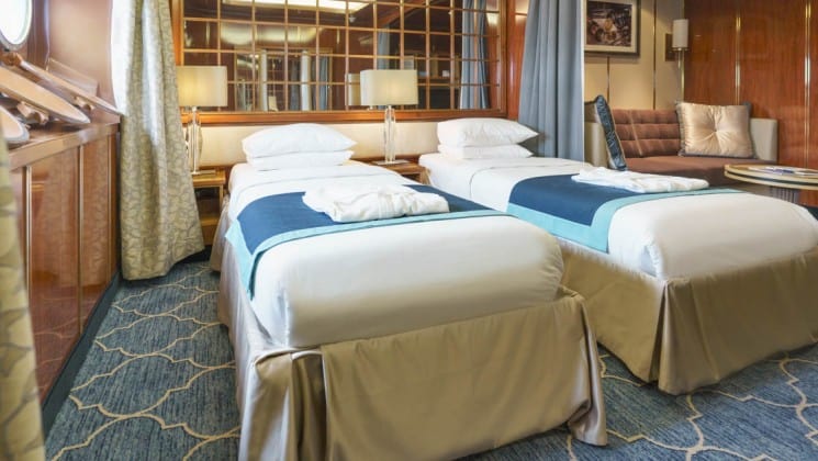 Two beds, couch and table in Main Deck Suite aboard Sea Spirit expedition ship