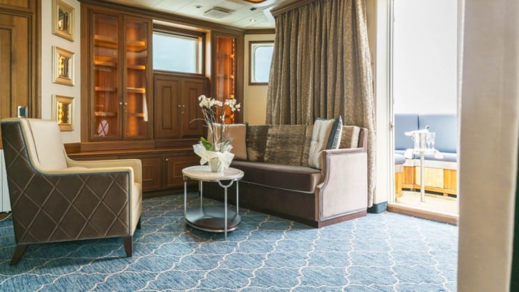 Sitting room with couch, armchair and coffee table in Owner's Suite aboard Sea Spirit small ship