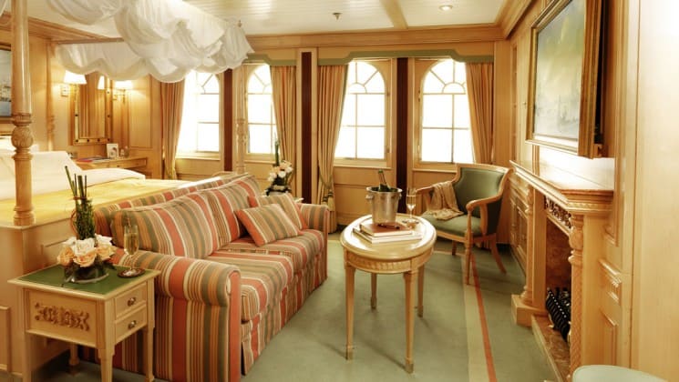 room with comfortable couch and large windows lining the walls aboard the sea cloud ii mediterranean luxury yacht