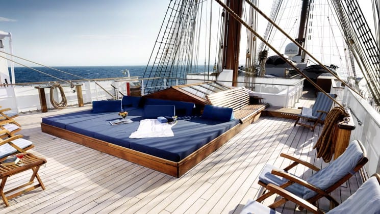 large lounge area on the deck of the sea cloud ii mediterranean luxury yacht with comfortable chairs lining it