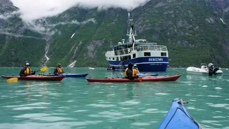 Kayakers in Alaskan waters off the stern of Sikumi yacht
