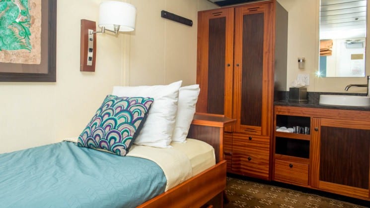 cabin with single bed, dresser, table and window aboard the Safari Voyager Costa Rica small ship