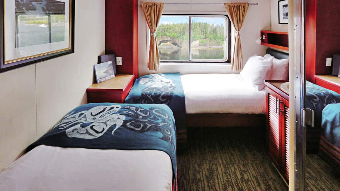 Category A stateroom with two twin beds perpendicular and window aboard Admiralty Dream