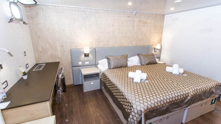 Adriatic Sun cabin room with large bed and desk.