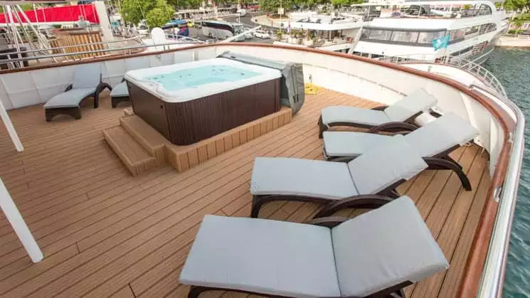 Adriatic Sun hot tub deck with hot tub and chaise lounges.